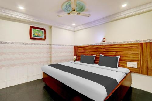 a bedroom with a bed and a ceiling fan at Collection O M G Road in Trivandrum