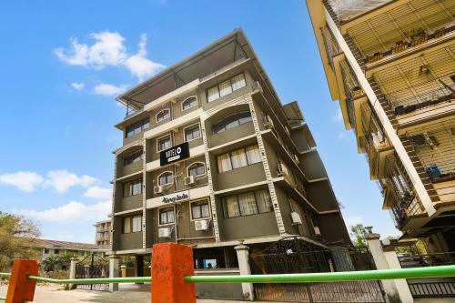 a tall gray building with a fence in front of it at Super Hotel O Dabolim Near Goa International Airport in Goa
