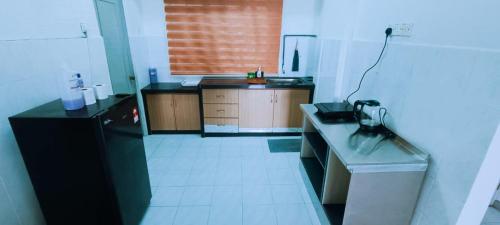 a kitchen with a black refrigerator and a counter at 3-Bedroom Homelike Apartment in Bukit Mertajam in Bukit Mertajam
