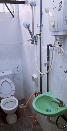 a bathroom with a toilet and a green table at 3-Bedroom Homelike Apartment in Bukit Mertajam in Bukit Mertajam