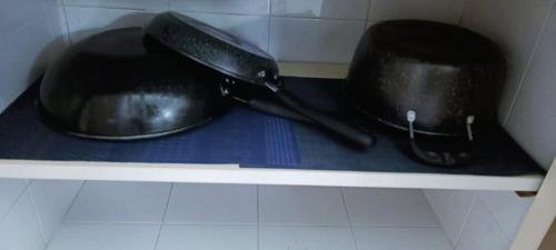 two pots and pans sitting on a shelf at 3-Bedroom Homelike Apartment in Bukit Mertajam in Bukit Mertajam