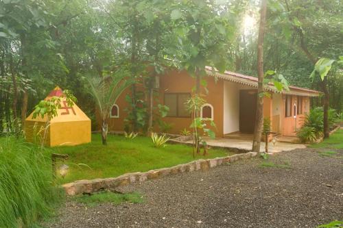 a house in the middle of a forest with a yard at VANN VAIKUNTHAM in Khawāsa