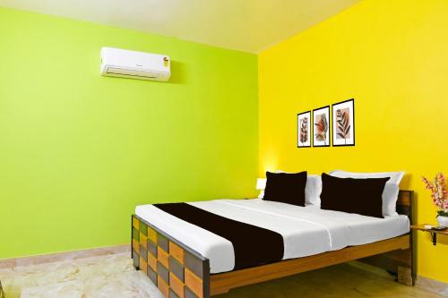 a bedroom with a bed with a green wall at Super Hotel O Kabardanga More Kolkata Formerly Royal Crown Banquet in Taliganja
