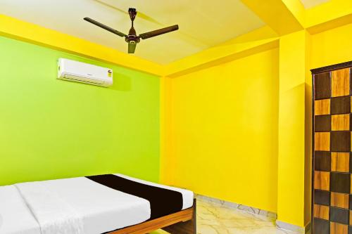 a bedroom with green and yellow walls and a ceiling at Super Hotel O Kabardanga More Kolkata Formerly Royal Crown Banquet in Taliganja