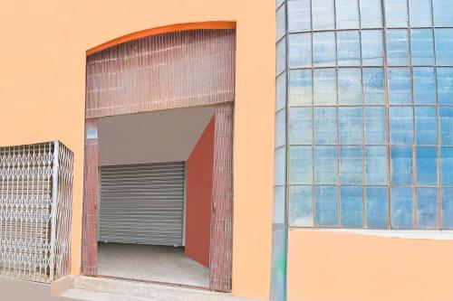 a building with a garage door and a window at Super Hotel O Kabardanga More Kolkata Formerly Royal Crown Banquet in Taliganja
