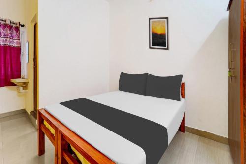 a bedroom with a bed in a room at Super Hotel O Okkilipalayam in Coimbatore