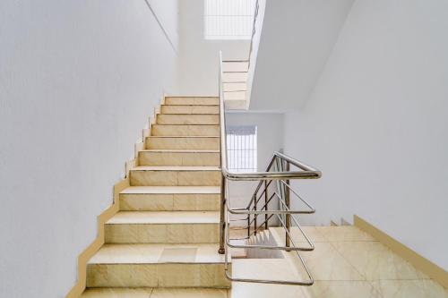 a staircase in a house with a metal handrail at Super Hotel O Okkilipalayam in Coimbatore