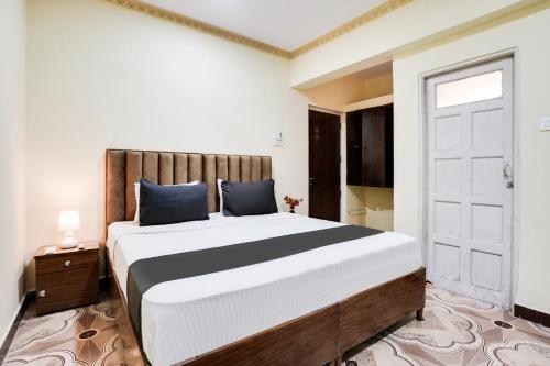 a bedroom with a large bed and a door at Super Collection O Calangute in Goa