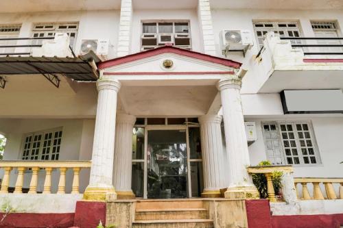a white house with columns at Super Collection O Calangute in Goa