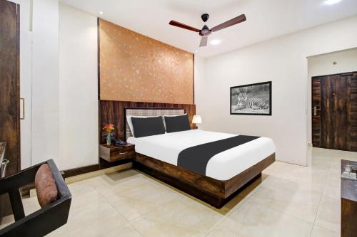 a bedroom with a bed and a ceiling fan at Hotel O Vijayawada Near Railway Station in Vijayawāda
