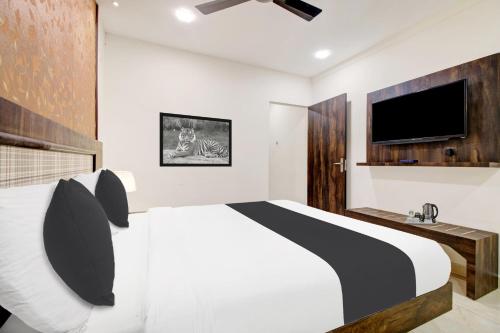 a bedroom with a bed and a flat screen tv at Hotel O Vijayawada Near Railway Station in Vijayawāda