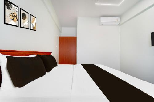 a bedroom with a bed with black and white sheets at Super Collection O Karumathampatti in Coimbatore