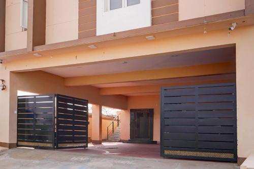 a garage with two black doors on a building at Super Collection O Karumathampatti in Coimbatore