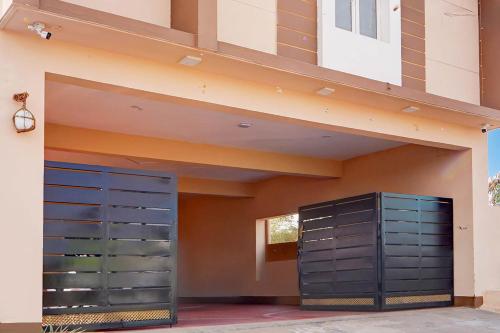 a garage with two blue doors on a building at Super Collection O Karumathampatti in Coimbatore