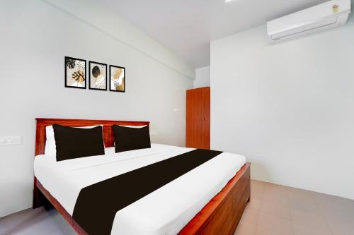 a bedroom with a black and white bed in a room at Super Collection O Karumathampatti in Coimbatore