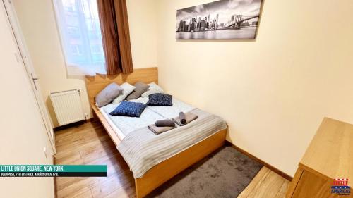 a small bedroom with a bed with two pillows at Little New York West Side Apartments in Budapest
