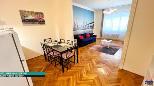 a living room with a table and a blue couch at Little New York West Side Apartments in Budapest