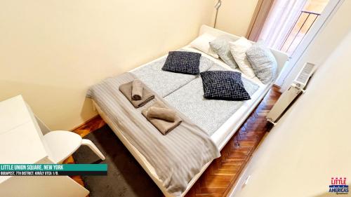 a bed with two pillows on it in a room at Little New York West Side Apartments in Budapest