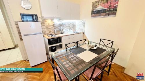 a small kitchen with a table and a refrigerator at Little New York West Side Apartments in Budapest