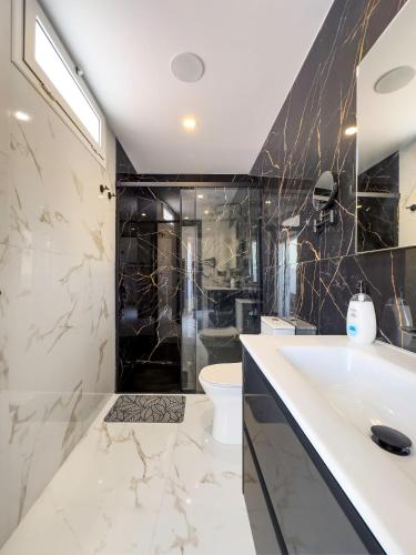a bathroom with a sink and a toilet at HH Riz Resort - Adults Only in Maspalomas