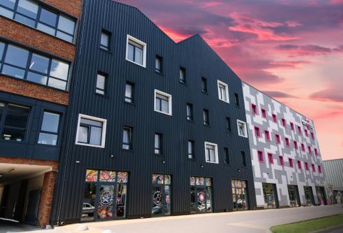 a black building with a sunset in the background at Amarant Urban Hotel by CHM in Kyiv