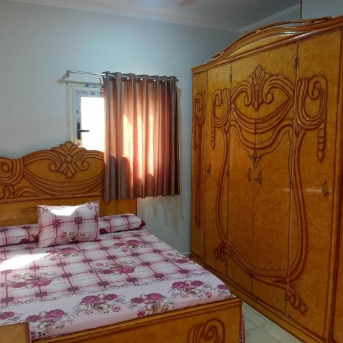 a bedroom with a bed and a large wooden cabinet at Hurghada City apartments Red sea in Hurghada