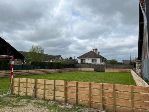 a fence in front of a yard with a house at L'Escapade d'Acquigny, Piscine, Foot Five, Salle de sport, BabyFoot in Acquigny