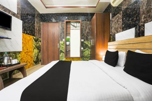 a bedroom with a large white bed and a window at Super Collection O Tikonia in Haldwāni