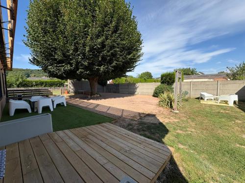 a wooden deck with a picnic table and a tree at L'Escapade d'Acquigny, Piscine, Foot Five, Salle de sport, BabyFoot in Acquigny