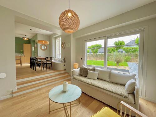 una sala de estar con un sofá y una mesa en Les oiselieres, plages a pieds, en Carnac