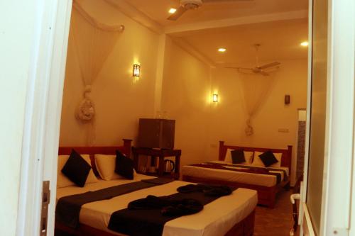 a hotel room with two beds and a television at Blue Sky in Mirissa