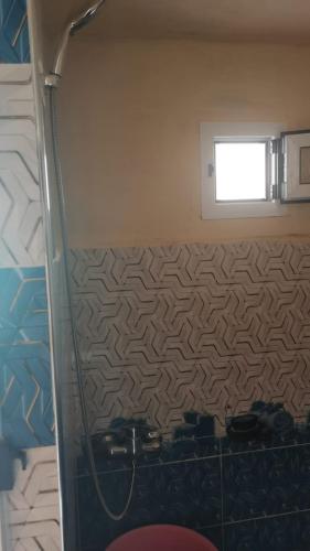 a bathroom with a shower and a window at Home family in Merzouga