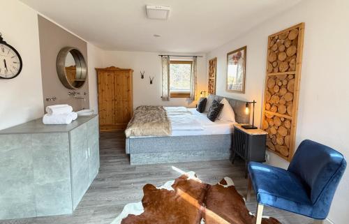 a bedroom with a large bed and a blue chair at CHALET BELLE KAISER by Belle Stay in Going