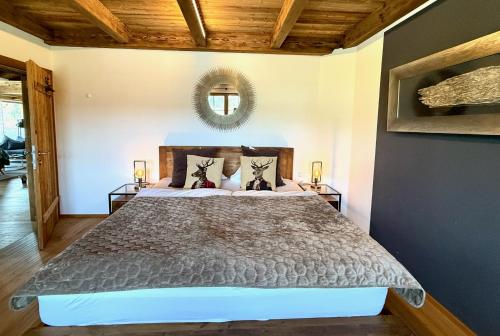 a bedroom with a bed and a mirror on the wall at CHALET BELLE KAISER by Belle Stay in Going
