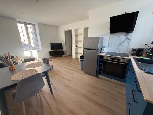 a room with a kitchen with a table and a refrigerator at Appartement T2 Neuf Pont-Réan in Guichen