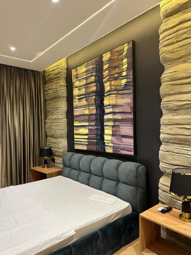 a bedroom with a bed and a painting on the wall at Hotel Kvirila in Tsinsopʼeli