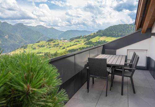 a balcony with a table and chairs and mountains at Aparthotel Fernblick in Fiss