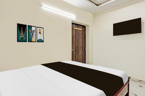 a white room with a bed and a door at Super Hotel O Lakshmipuram Main Road Guntur in Guntūr