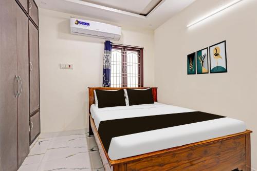 a bedroom with a bed in a room at Super Hotel O Lakshmipuram Main Road Guntur in Guntūr