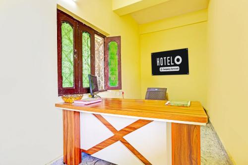 an office with a wooden desk with a computer on it at Super Hotel O Lakshmipuram Main Road Guntur in Guntūr