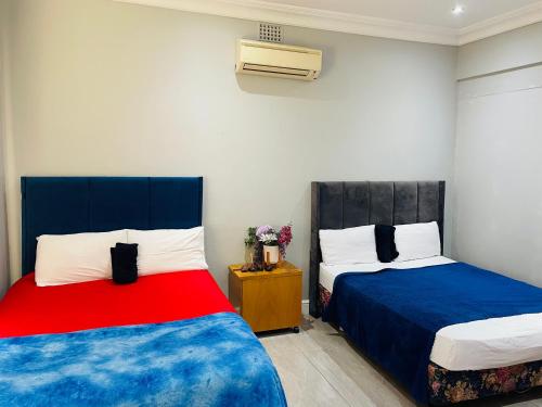 a bedroom with two beds and a air conditioner at ANNIKA B&B Claremont in Cape Town