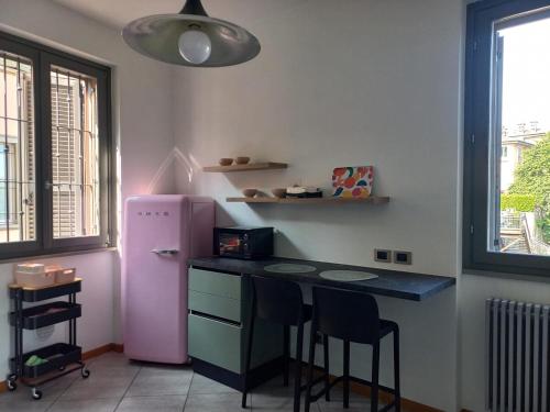 a kitchen with a table and a pink refrigerator at Luminoso appartamento panoramico in Cassano dʼAdda
