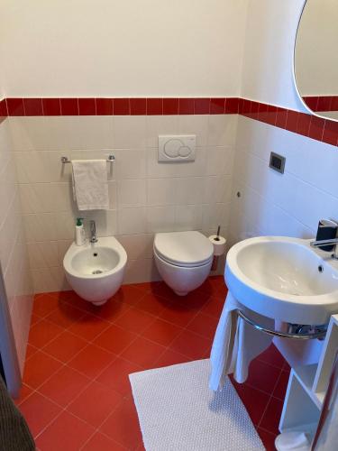 a bathroom with a white sink and a toilet at Luminoso appartamento panoramico in Cassano dʼAdda