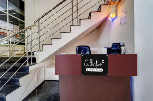 a cashier counter in a building with stairs at Super Collection O Kottayam Formerly Sap Inn in Kottayam