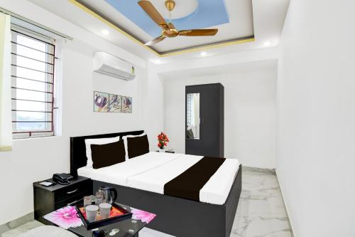 a bedroom with a bed and a ceiling fan at Super Collection O Mourigram Near Andul Road in Sānkrāil