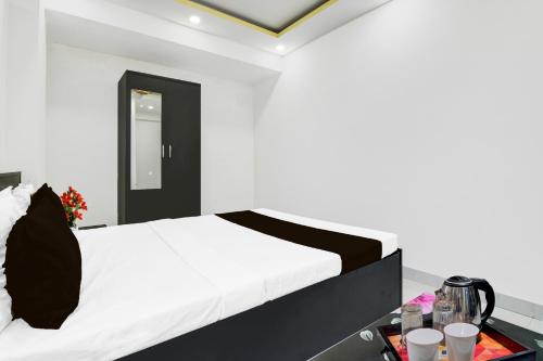 a bedroom with a bed and a table with drinks at Super Collection O Mourigram Near Andul Road in Sānkrāil