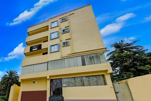a tall yellow building with a blue sky in the background at Super Collection O Mourigram Near Andul Road in Sānkrāil