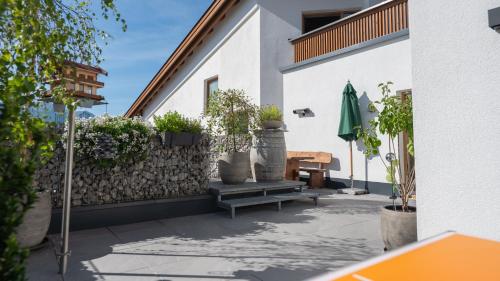a patio with a bench and a wall with plants at Aparthotel Fernblick in Fiss