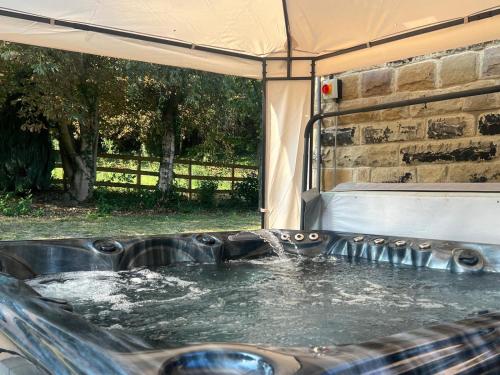 a hot tub in a tent with water in it at Hayy Luxury Retreat At The Lodge in Bradford