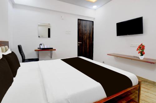 a bedroom with a white bed and a television at Super Collection O Hinjewadi Phase 1 Formerly Mars Venture in Hinjewadi
